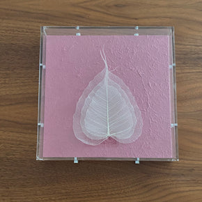 O quadro FOLHA SUAVE mostra folhas naturais esqueletizadas através de técnica ancestral, emolduradas em caixa de acrílico. Encantador!