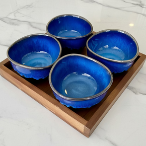 Petisqueira com 4 bowls azuis e pretos em bandeja de madeira. Moderna, é ideal para servir petiscos com praticidade. Garanta a sua!