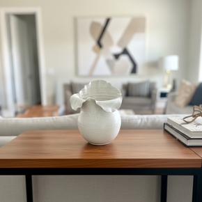 Vaso em cerâmica off white com formato orgânico e bordas onduladas. 