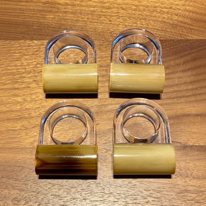 Kit 4 anéis de guardanapo em acrílico e bambu natural, destacando a transparência do acrílico e a textura orgânica do bambu.
