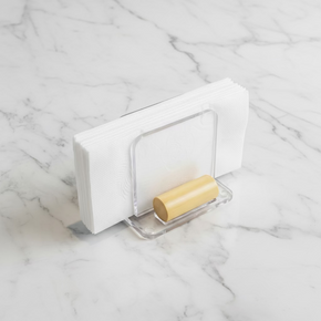 Porta-guardanapos de acrílico com detalhe cilíndrico de bambu natural segurando guardanapos de papel brancos.