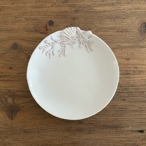 Prato de sobremesa em melamina premium. Detalhe de estrela-do-mar e concha em relevo na borda, ideal para decoração de mesa posta sofisticada e prática.