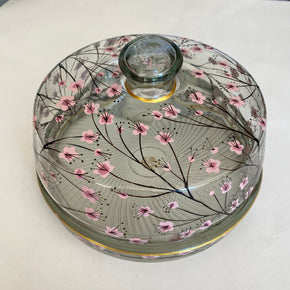 Detalhe da pintura à mão de galhos e flores de cerejeira na tampa da queijeira de vidro.