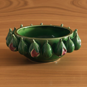 O centro de mesa tem esmalte verde com efeito craquelado sutil na cerâmica, destacando o relevo de figos abertos com o interior avermelhado e realista.