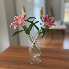 Vaso de vidro transparente com 2 tubos usado em arranjo floral minimalista.