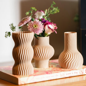 Trio de mini vasos cor areia feitos em 3D e moldados por mãos humanas.